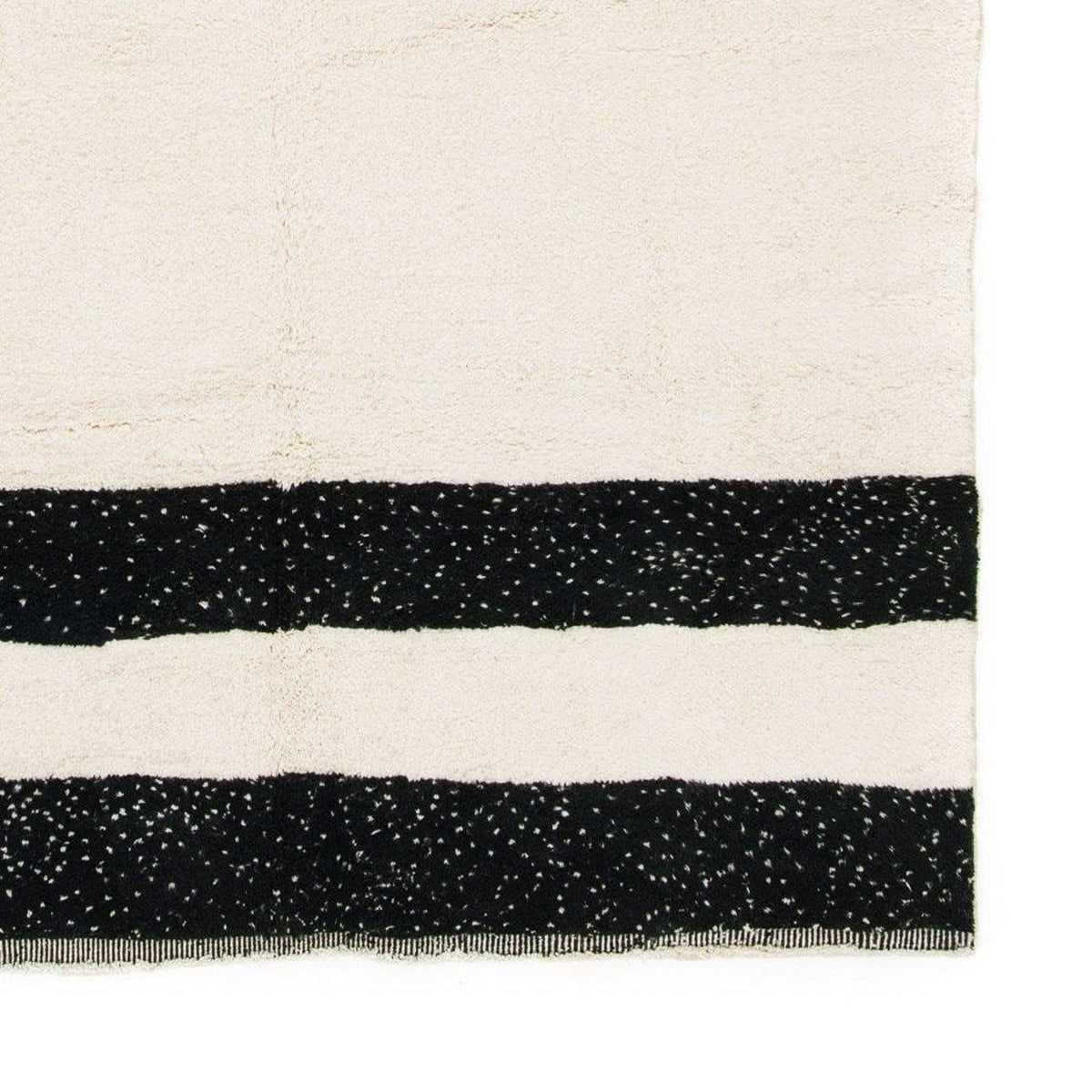 Detail close-up of the black and cream striped Moroccan rug featuring a geometric design.
