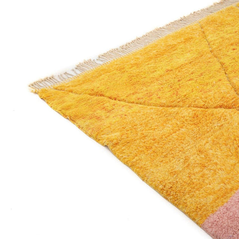Close-up detail of the yellow rug corner showing textured surface at an angle.