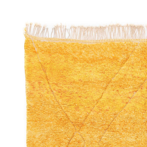 Close-up detail of the orange and pink rug showcasing fringe edge and soft texture.