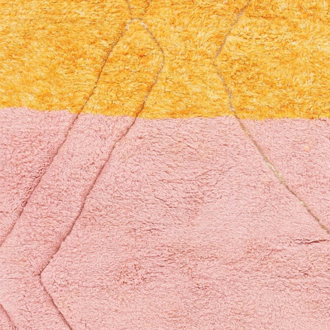 Close-up detail of the orange and pink rug highlighting the textured surface.