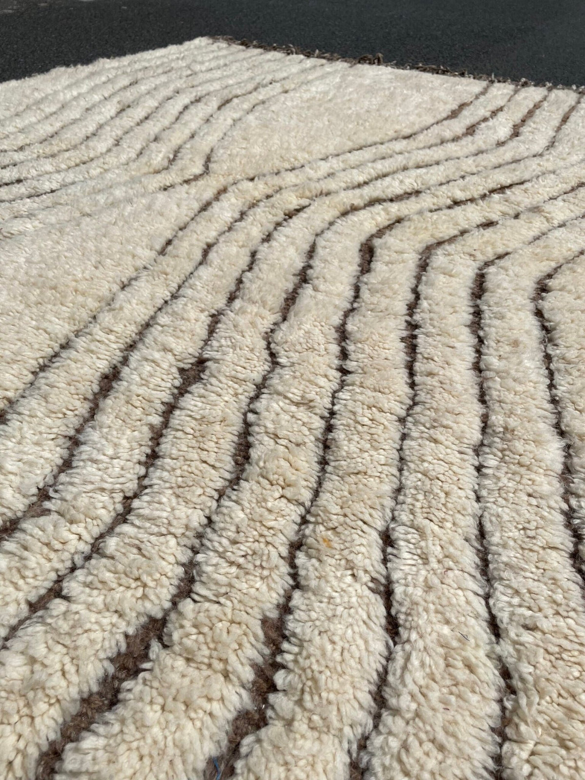 Detail close-up of the edge of the Soft Ivory Textured Custom Beni Ourain Moroccan Rug with a striped pattern.