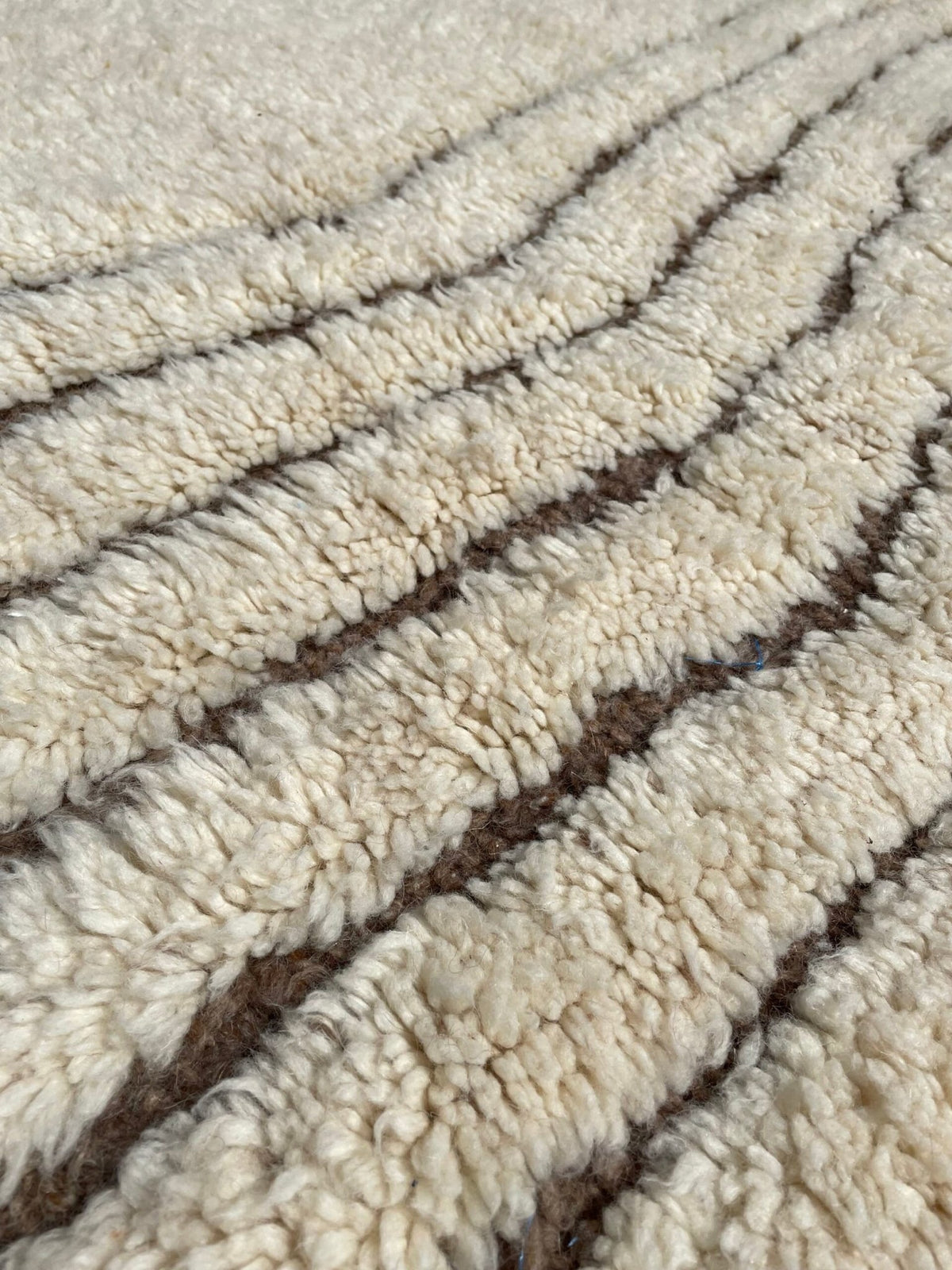 Detail close-up of the textured surface of the Soft Ivory Textured Custom Beni Ourain Moroccan Rug highlighting geometric…