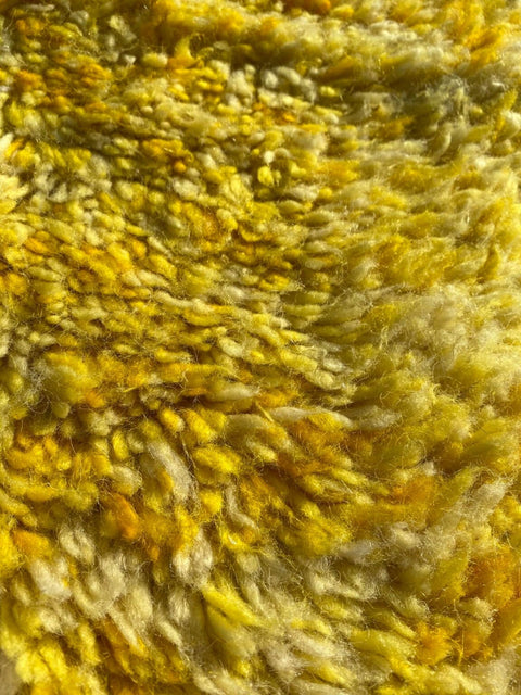 Close-up detail of a yellow Moroccan rug highlighting its textured surface and soft fibers.