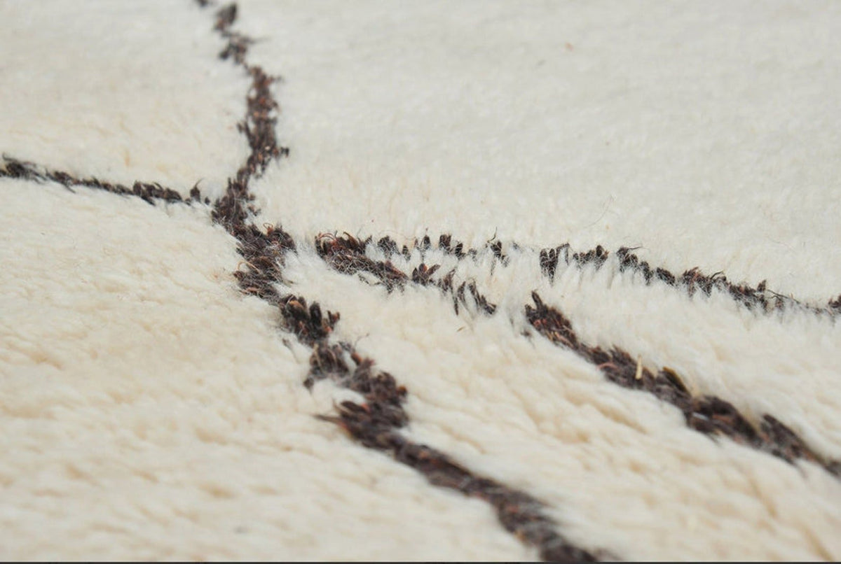 Detail shot highlighting the abstract lines of the black and off-white rug pattern.