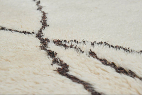 Detail shot highlighting the abstract lines of the black and off-white rug pattern.
