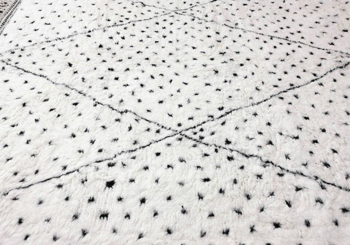 Close-up detail of a Moroccan rug showcasing a detailed pattern in white and black.