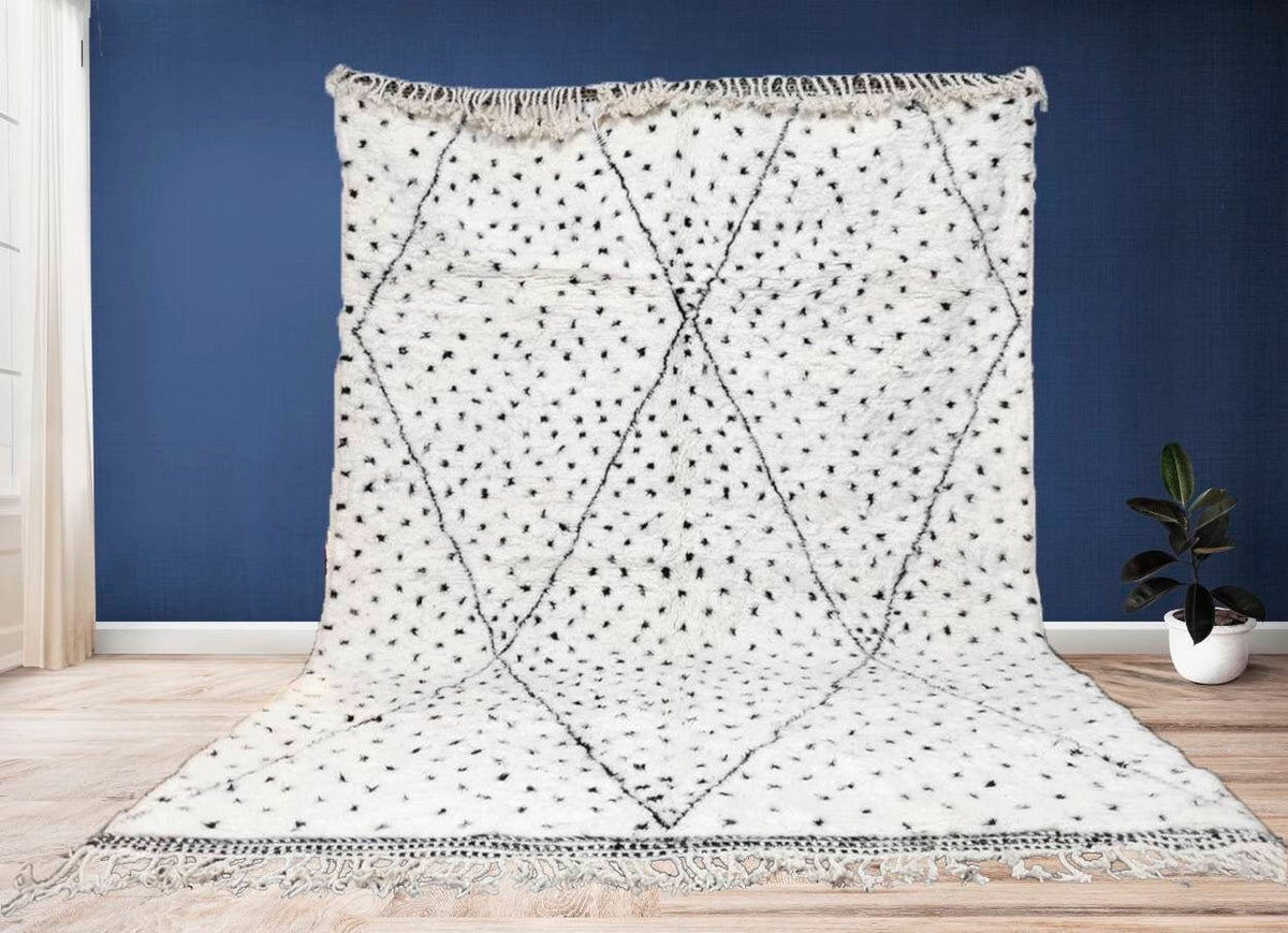 Lifestyle shot of a geometric pattern Moroccan rug in white and black colors.