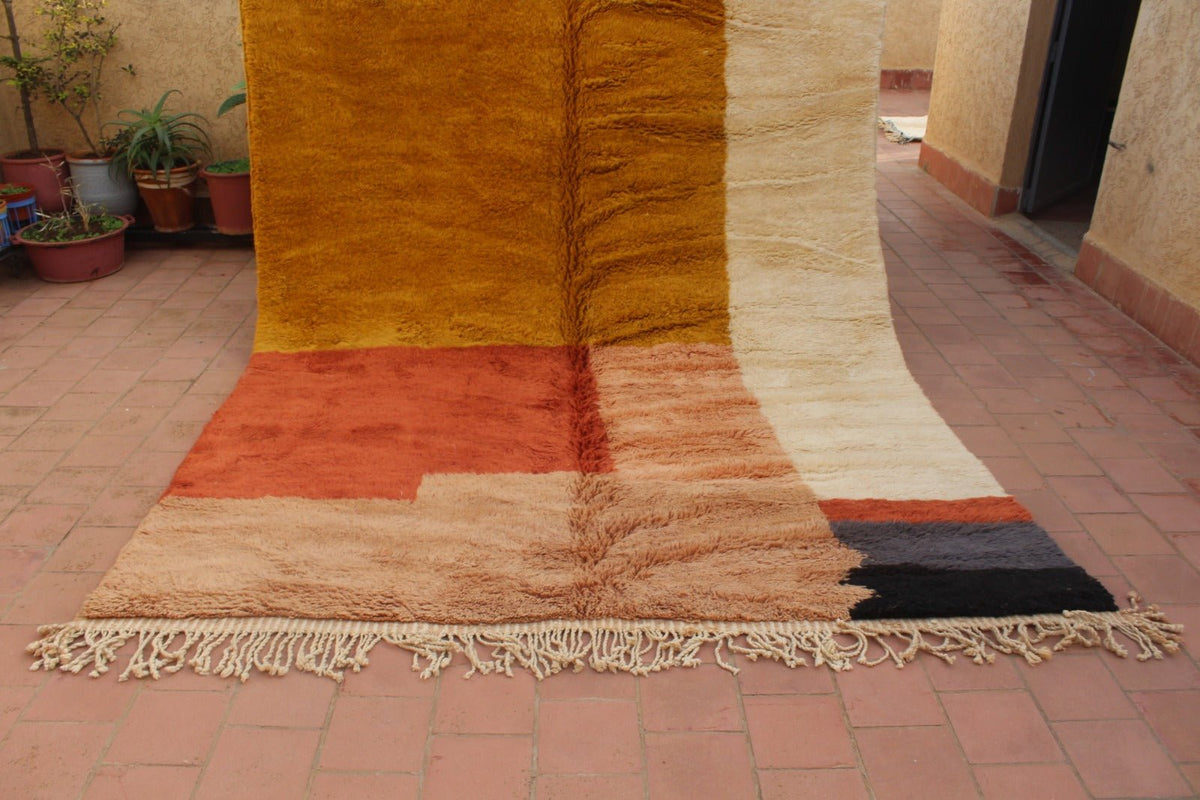 Front view of a brown and beige Beni Ourain rug with an abstract pattern on a natural background.