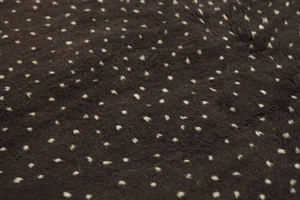 Close-up detail of the textured surface of the black and off-white Beni Ourain Moroccan rug.