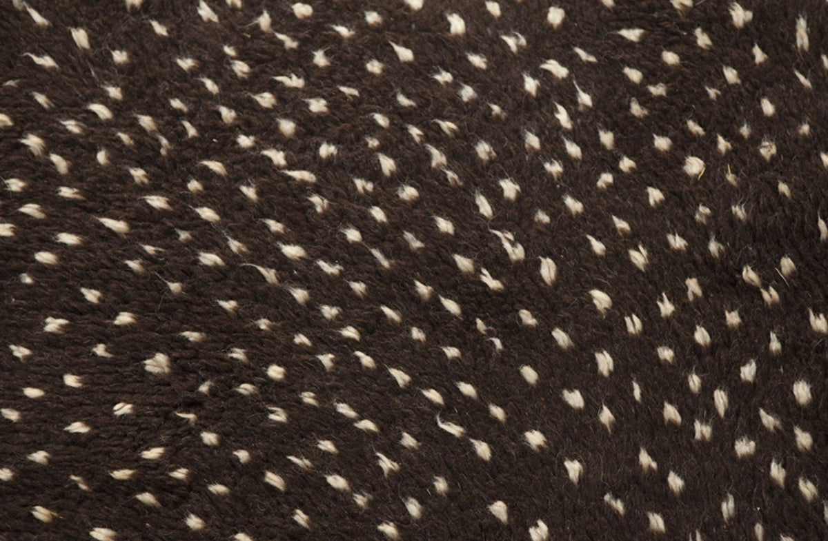 Close-up detail highlighting the patterned design of the black and off-white Beni Ourain Moroccan rug.