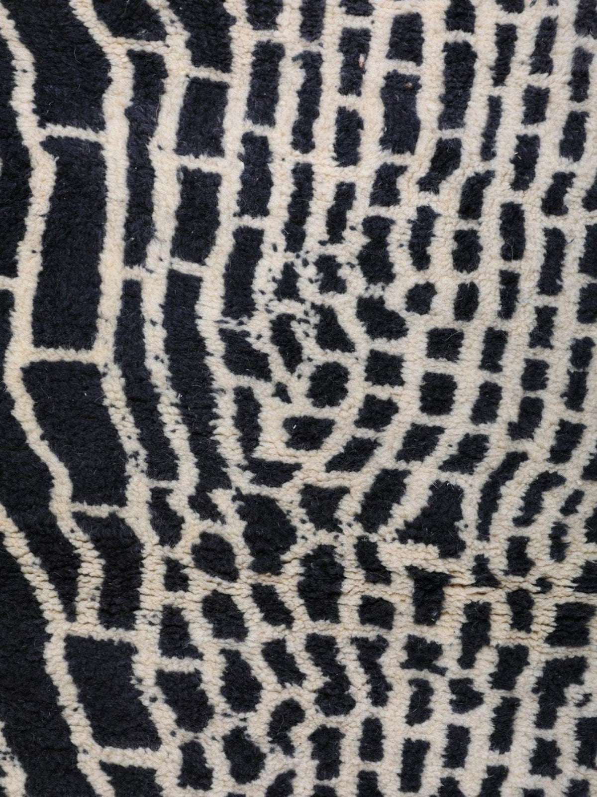 Close-up detail of a black area rug showcasing an abstract design and soft texture.