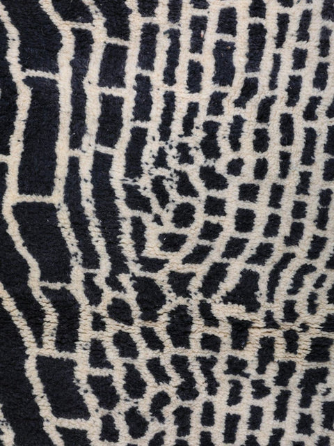 Close-up detail of a black area rug showcasing an abstract design and soft texture.