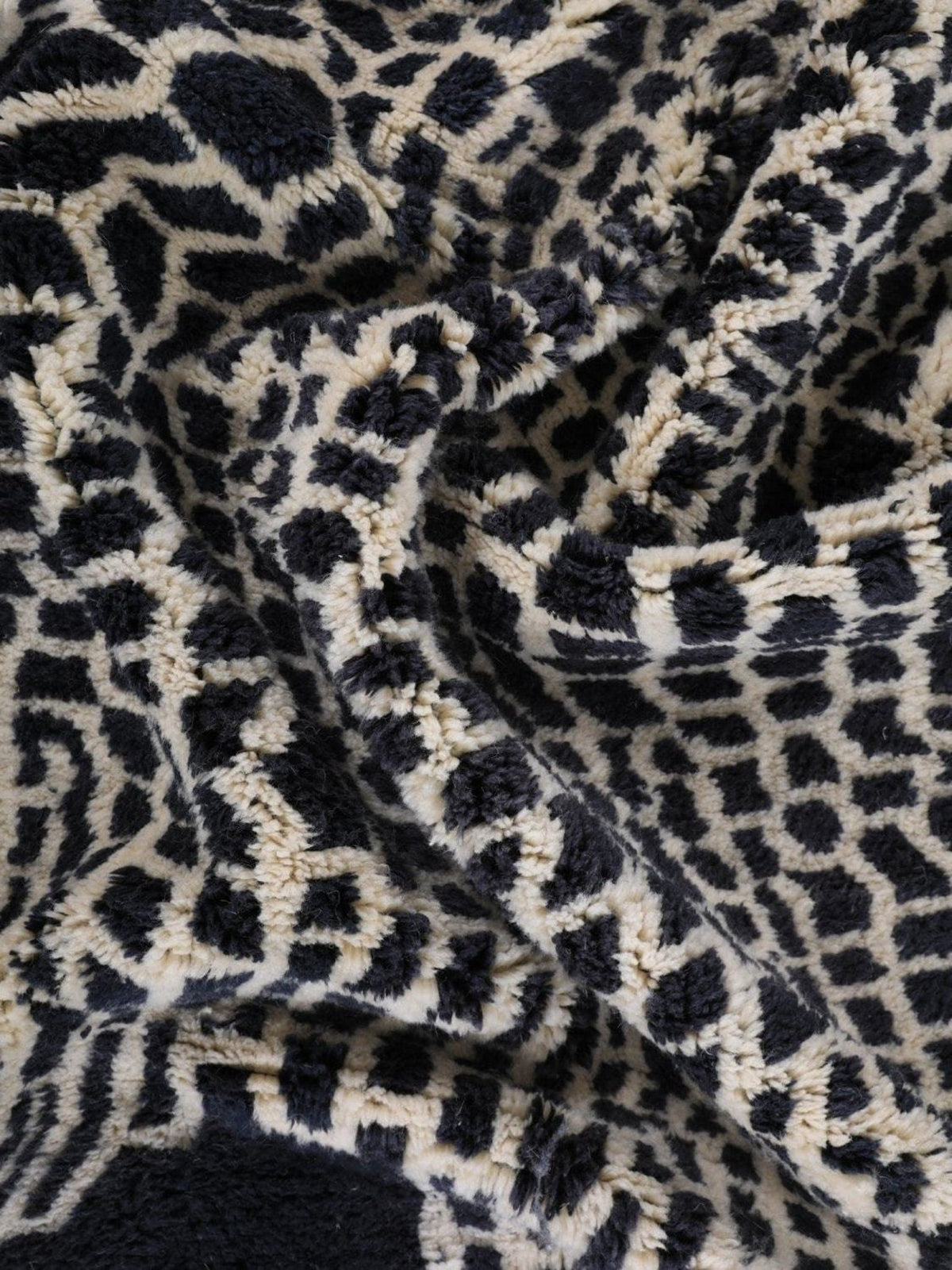 Detail shot of the textured surface of a black and beige woven rug.