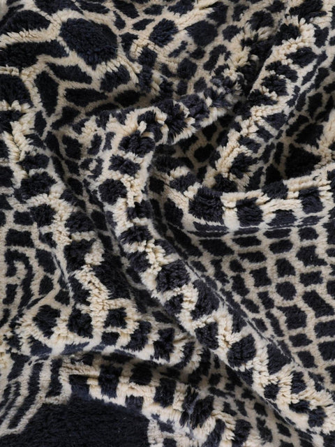 Detail shot of the textured surface of a black and beige woven rug.