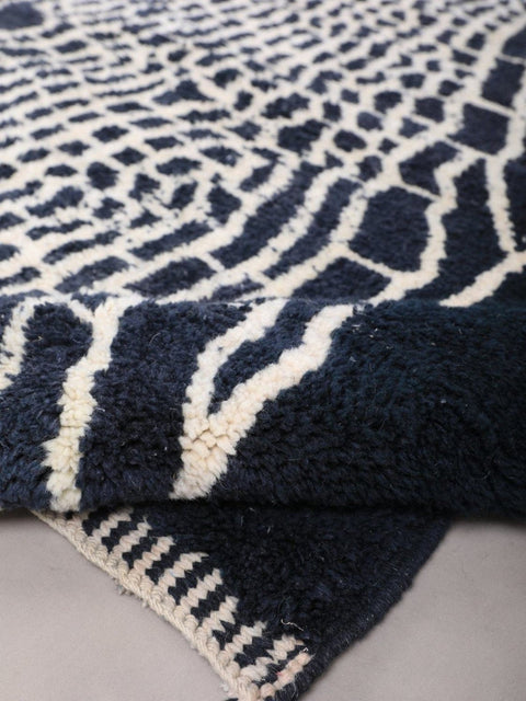 Detail view of a black and white rug with an abstract pattern.