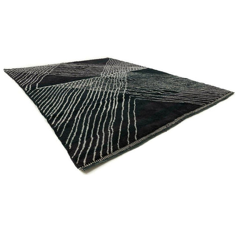 Side view of a black area rug featuring a geometric pattern and soft texture.