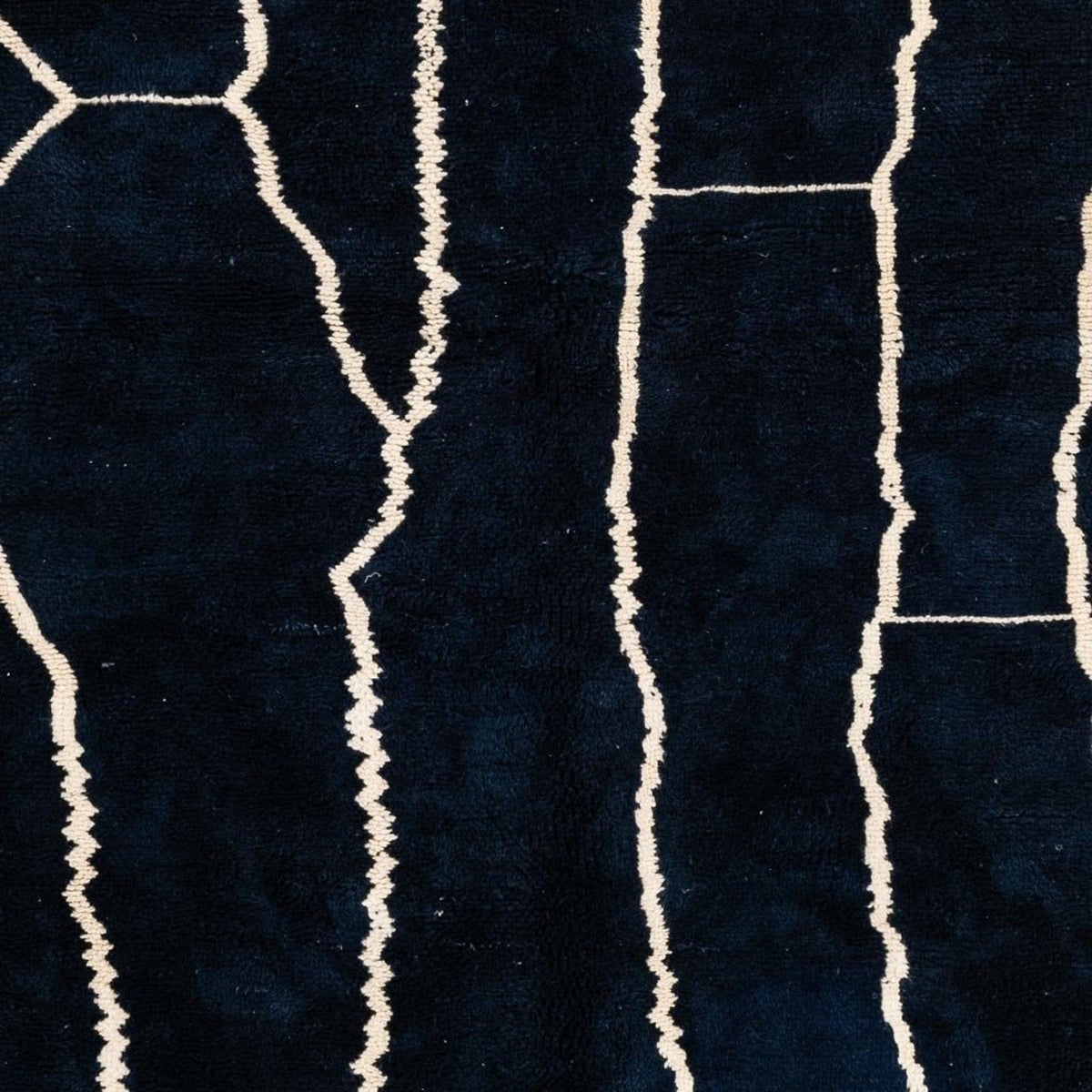 Detail view of a black and white abstract Beni Ourain Moroccan rug showcasing its handmade quality.