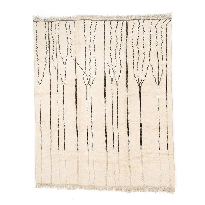Detail of a black and white geometric pattern on the beige striped Moroccan rug.