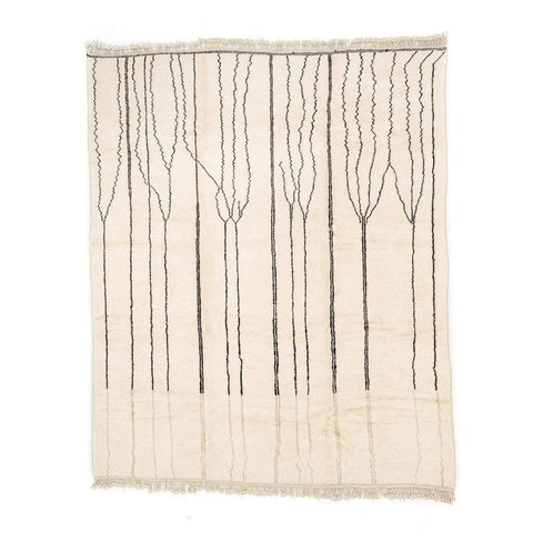 Detail of a black and white geometric pattern on the beige striped Moroccan rug.