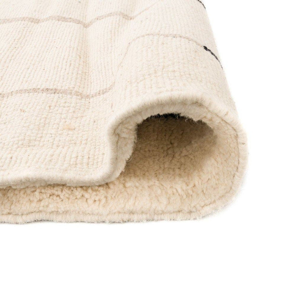 Close-up of the geometric pattern on the beige striped Moroccan area rug.