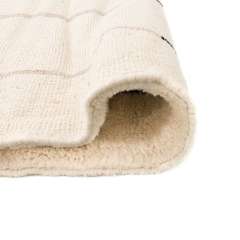 Close-up of the geometric pattern on the beige striped Moroccan area rug.