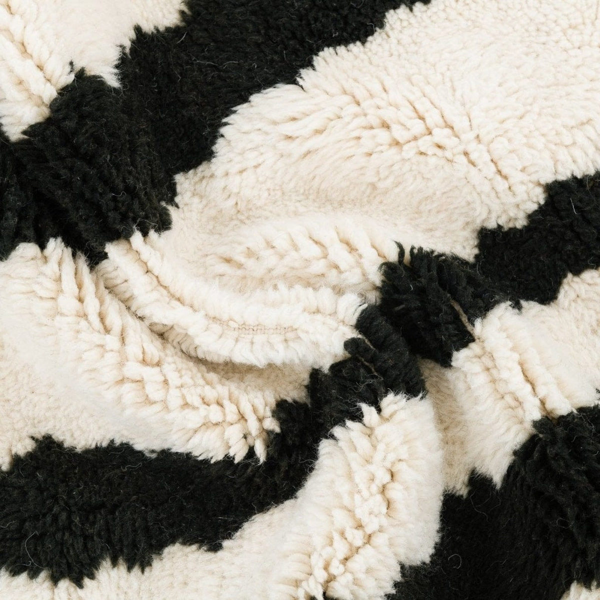 Close-up detail of the black and cream striped Beni Ourain Moroccan rug showcasing its textured surface.