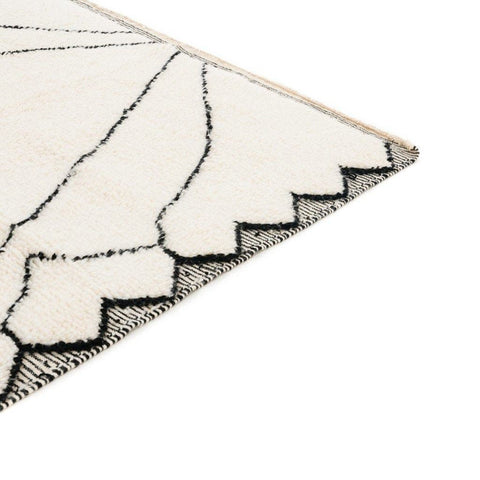 Side view of the ivory diamond Moroccan area rug with a textured surface and edge detail.
