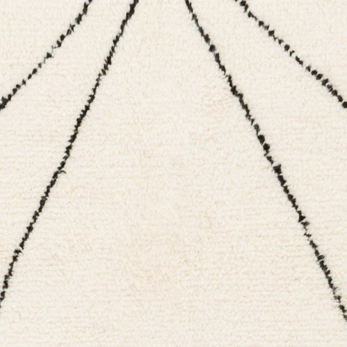 Close-up detail of the black and white Moroccan rug displaying line patterns and a soft texture.