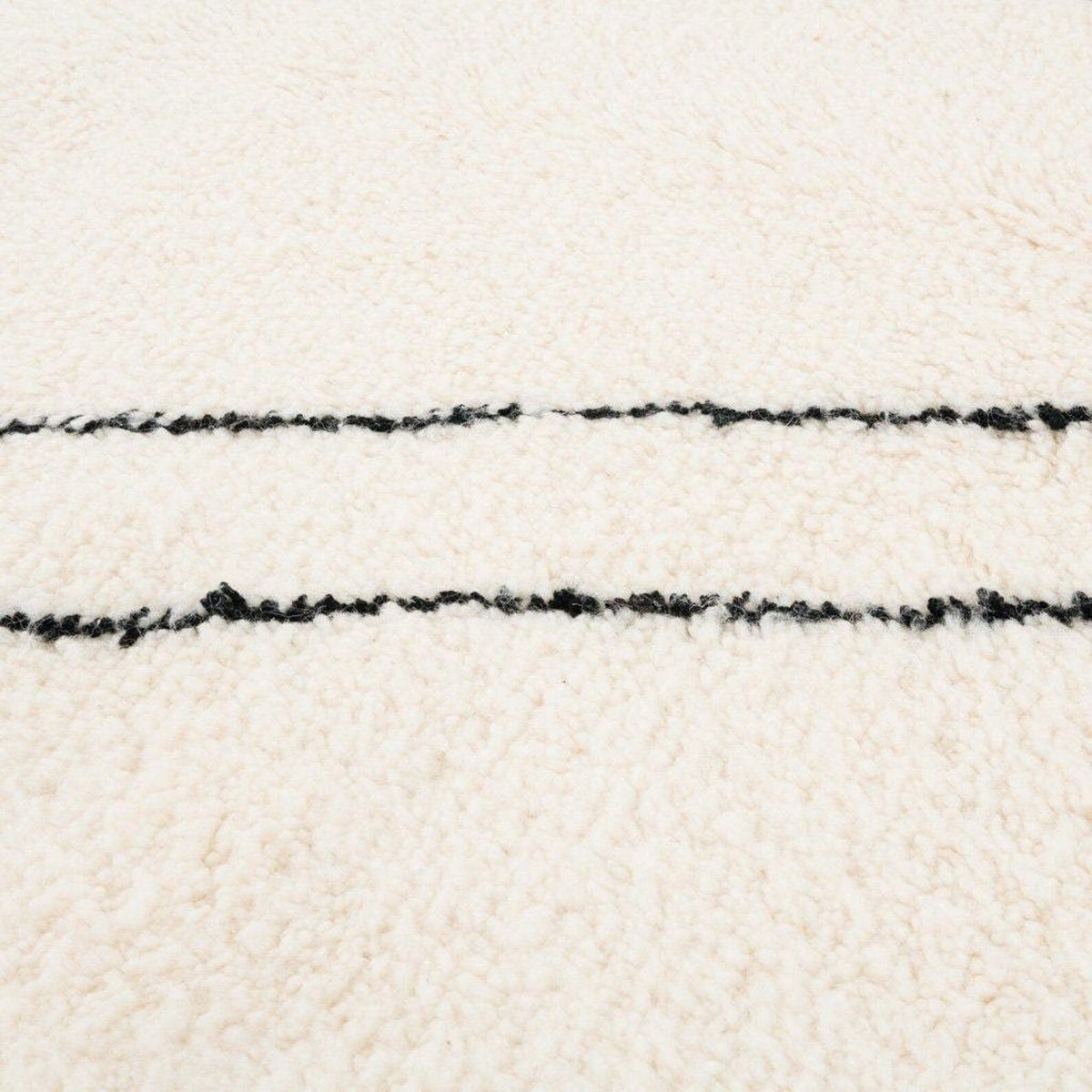 Close-up detail of the ivory diamond Moroccan area rug highlighting its thick pile and woven design.