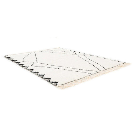 Close-up detail of the black and white Moroccan rug with a geometric pattern and soft texture.