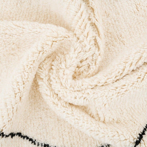 Close-up detail of the ivory diamond Moroccan area rug showcasing its soft texture.