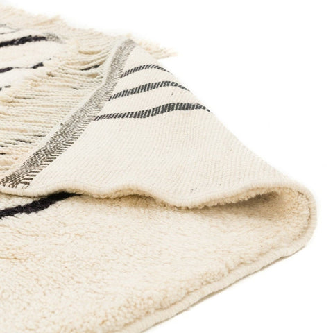 Detail close-up of a thick pile black and white striped area rug with textured stripes.