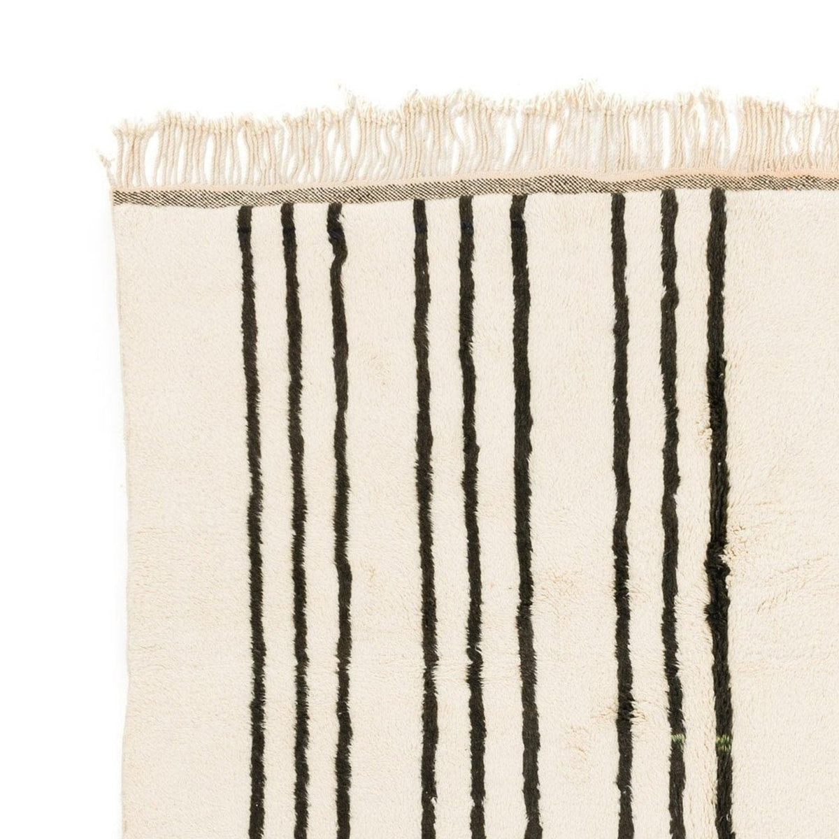 Detail close-up of a black and white striped area rug featuring a fringed edge.