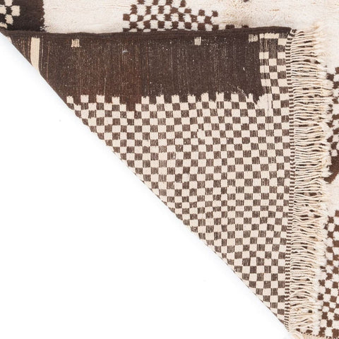 Close-up showing fringe edges and geometric pattern on the rug.