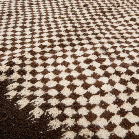 Close-up of a geometric design on a black and white Moroccan rug.