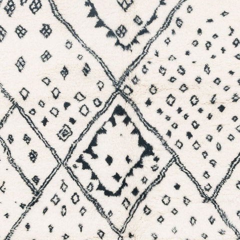 Close-up detail of the ivory geometric tribal area rug highlighting its black tribal pattern.