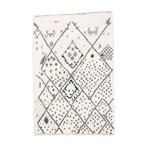 Front view of the ivory geometric tribal area rug featuring a black pattern.
