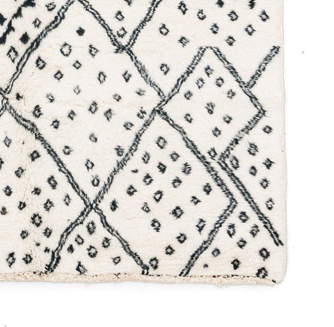 Front view of the ivory geometric tribal area rug showcasing a black tribal design.