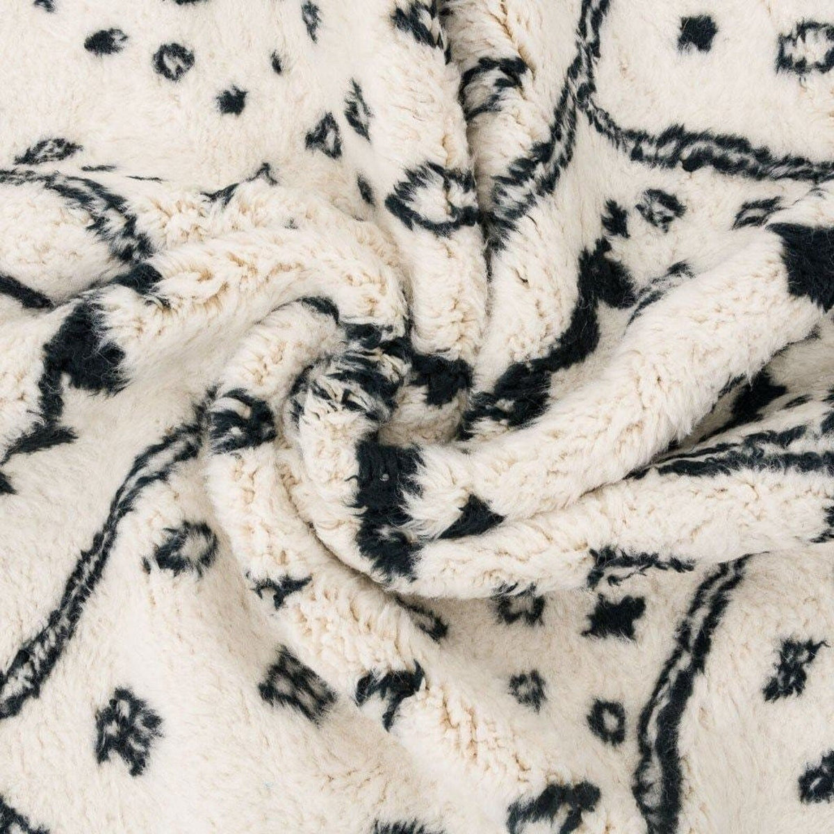 Close-up detail of the ivory geometric tribal area rug with a focus on its texture and design.