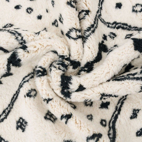 Close-up detail of the ivory geometric tribal area rug with a focus on its texture and design.