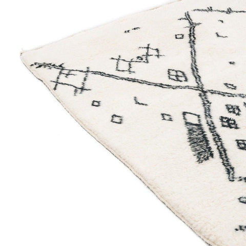 Close-up detail of the ivory geometric tribal area rug showcasing its black tribal pattern.