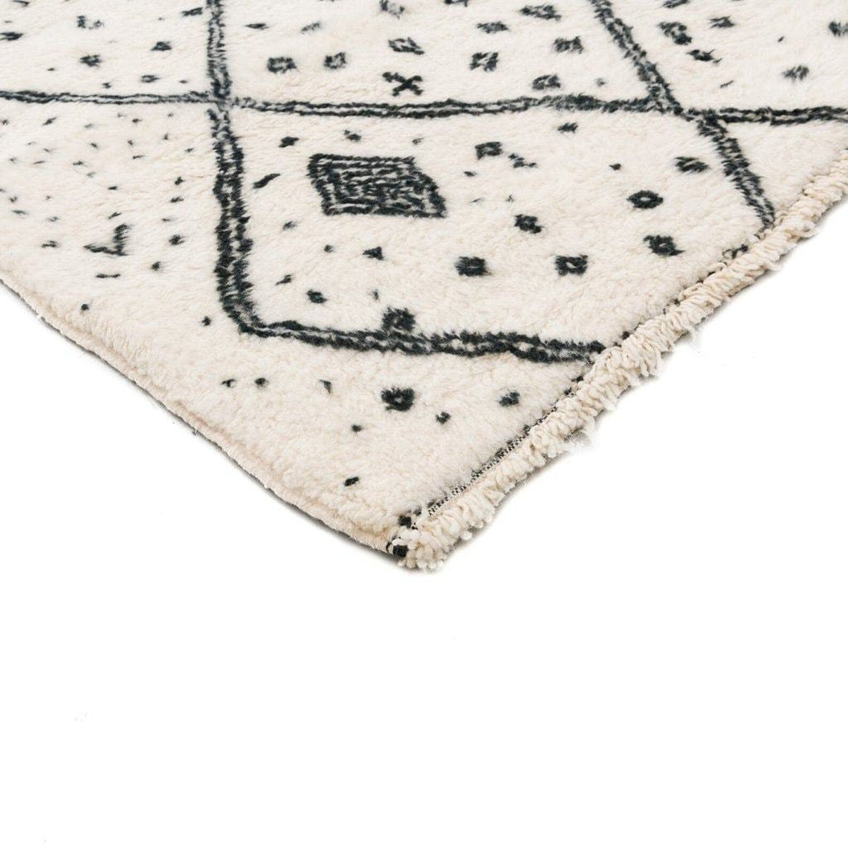 Close-up detail of the ivory geometric tribal area rug with a focus on its soft texture.