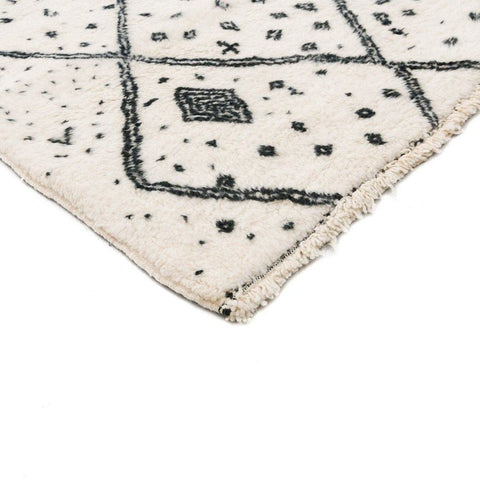 Close-up detail of the ivory geometric tribal area rug with a focus on its soft texture.
