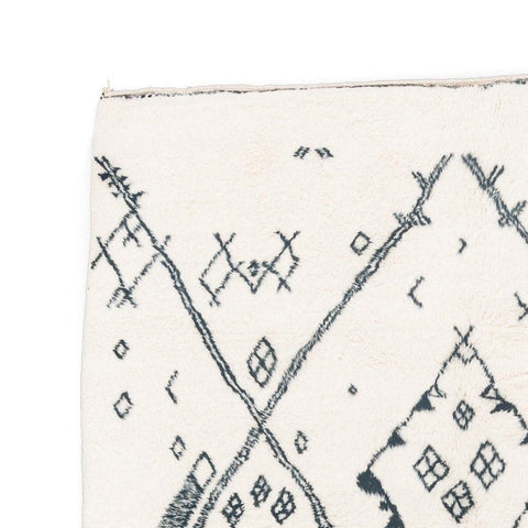 Close-up detail of the ivory geometric tribal area rug emphasizing the black tribal design.