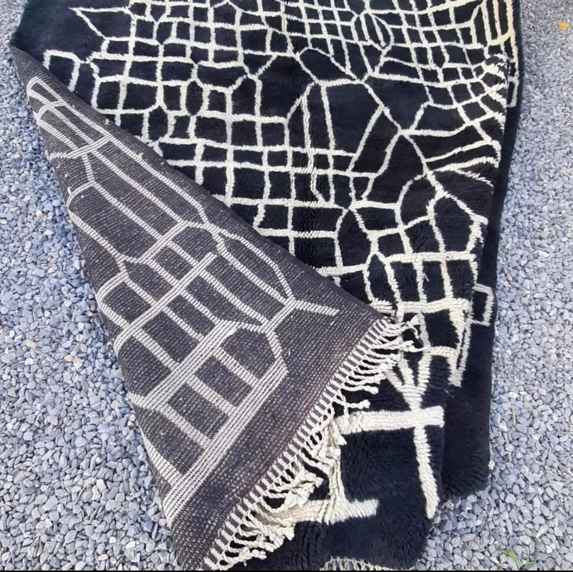Detail shot of a black Moroccan Berber rug highlighting its textured surface.