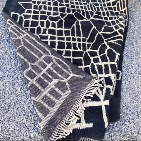 Detail shot of a black Moroccan Berber rug highlighting its textured surface.
