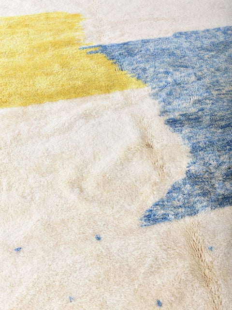 Detail close-up of the blue and yellow color block rug highlighting its soft texture.