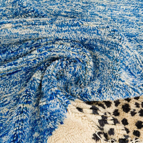 Close-up detail of the blue abstract rug featuring a textured pattern.