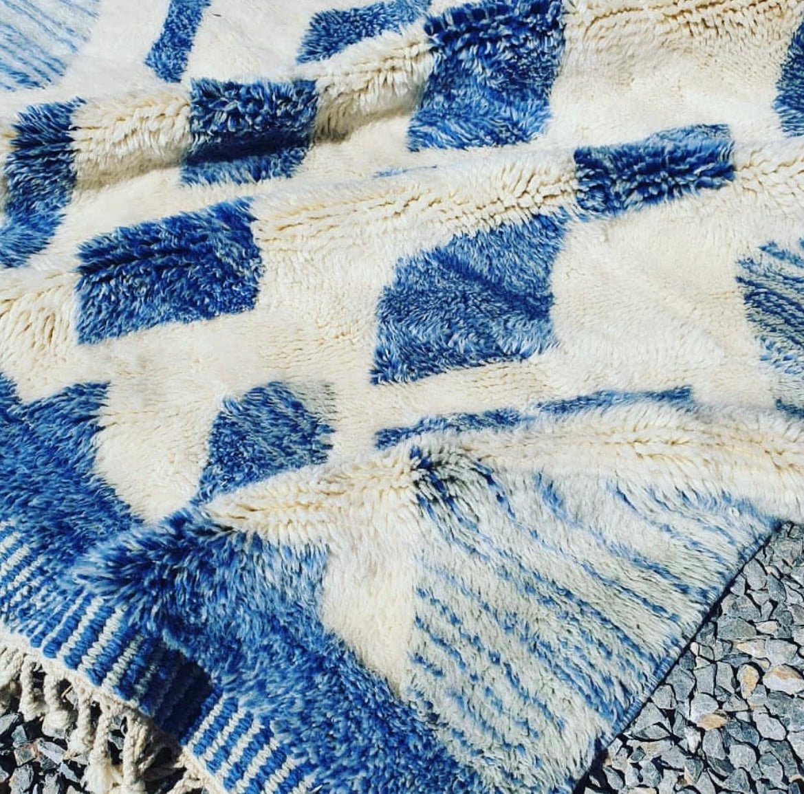 Close-up detail of the textured surface and geometric design of the blue Moroccan rug.