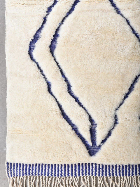 Detail view highlighting the abstract pattern on a blue and cream Moroccan rug.